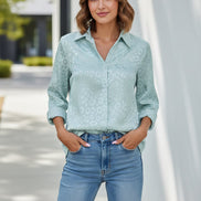 Woman wearing a light blue leopard print shirt against a plain background
