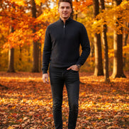 Dark gray half-zip sweater and watch on a gray surface