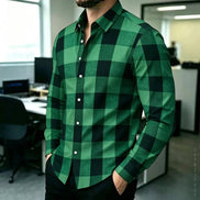 A man wearing a green and black buffalo plaid long-sleeve button-down shirt in an office environment.