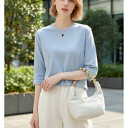 Woman wearing a light blue top with a white background