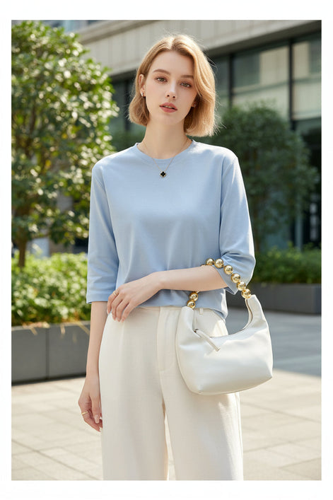 Woman wearing a light blue top with a white background