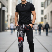 Black sweatpants with wolf and moon design on a white background