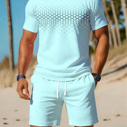 A man wearing a light blue matching swim set consisting of a short-sleeve t-shirt with a black geometric pattern across the chest and matching drawstring shorts, 