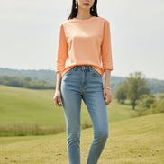 Person wearing a peach-colored dress with a blurred clothing store background