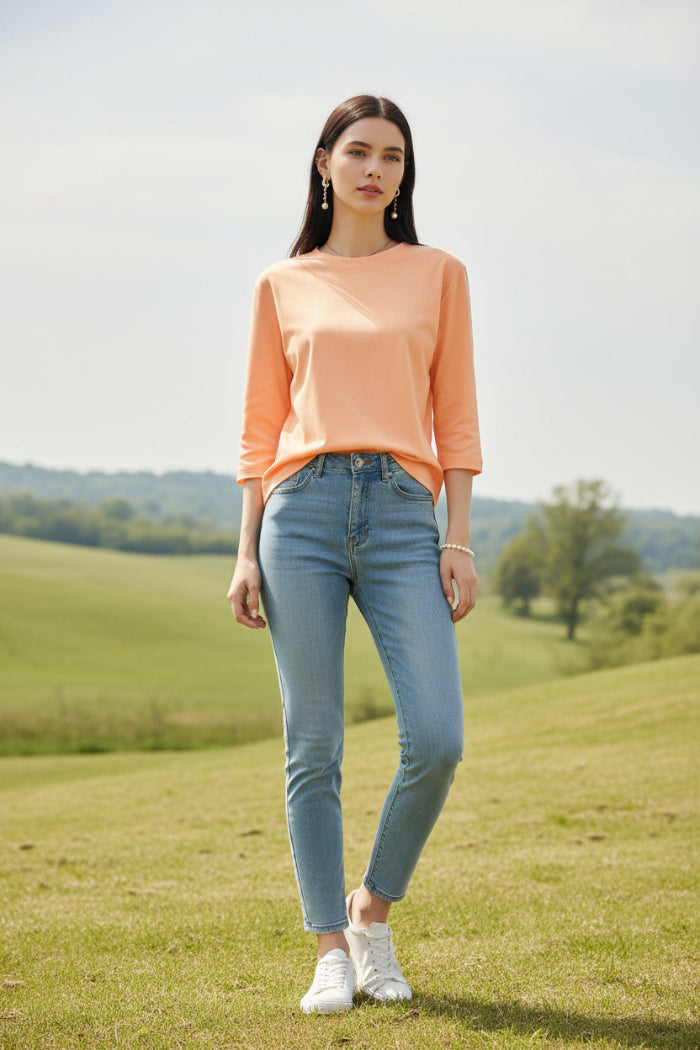 Person wearing a peach-colored dress with a blurred clothing store background