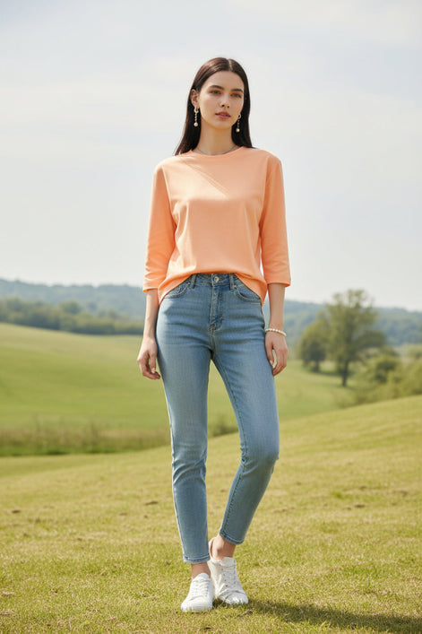 Person wearing a peach-colored dress with a blurred clothing store background