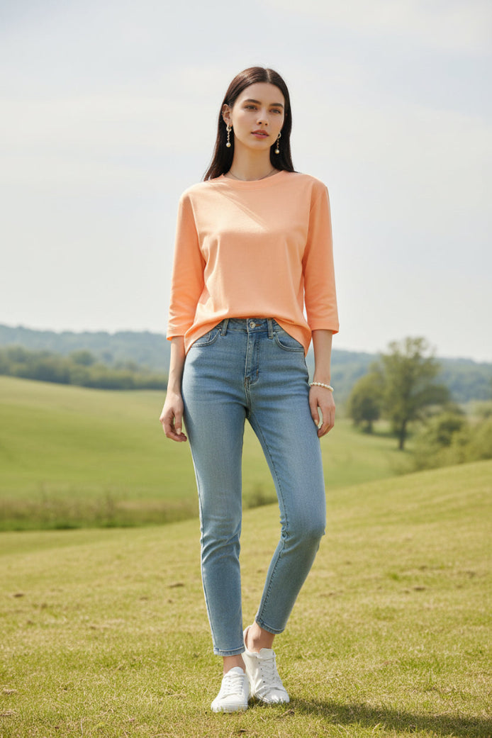 Person wearing a peach-colored dress with a blurred clothing store background