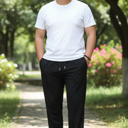 Person wearing black pants with a plain background