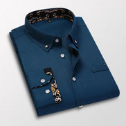 Folded blue dress shirt with decorative inner lining on a light gray background