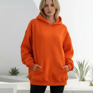 Orange hoodie worn by a person on a white background