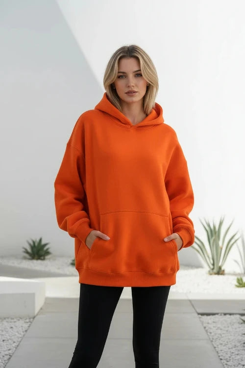 Orange hoodie worn by a person on a white background