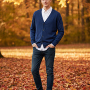 Blue cardigan over a white shirt on a wooden hanger against a wooden background
