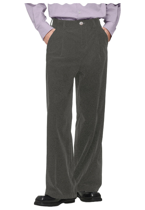 A person wearing dark olive gray wide-leg corduroy trousers, styled with a light purple off-the-shoulder shirt and black shoes, 