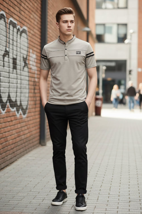 Man wearing a light gray polo shirt with black accents on a dark background
