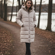Beige long puffer coat on a mannequin against a white background
