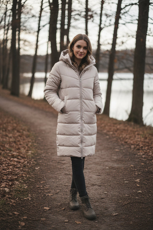 Beige long puffer coat on a mannequin against a white background