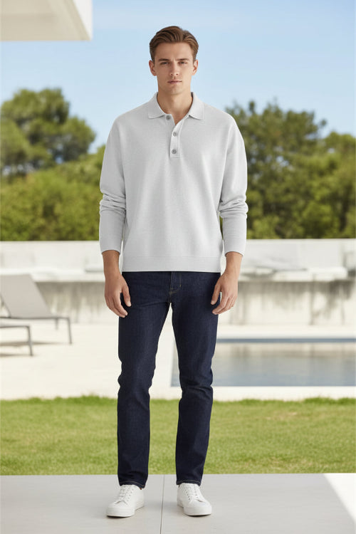 Person wearing a light gray long-sleeve polo shirt against a beige background
