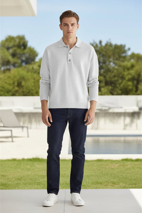Person wearing a light gray long-sleeve polo shirt against a beige background
