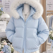A light blue puffer jacket with a large white faux-fur trimmed hood, displayed on a mannequin in a boutique setting.