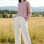Person wearing a pink sweater with a blurred background