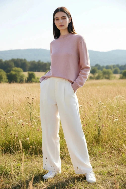 Person wearing a pink sweater with a blurred background