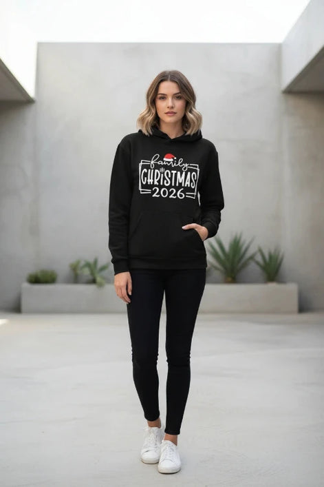 A black pullover hoodie laid flat with a festive white graphic reading 'family Christmas 2026' and a small Santa hat accent, 