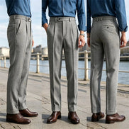 Three views of gray herringbone pleated suit trousers worn with a blue shirt, taken by the water