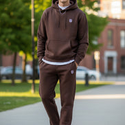 Brown sweatpants with a logo on a gray concrete surface