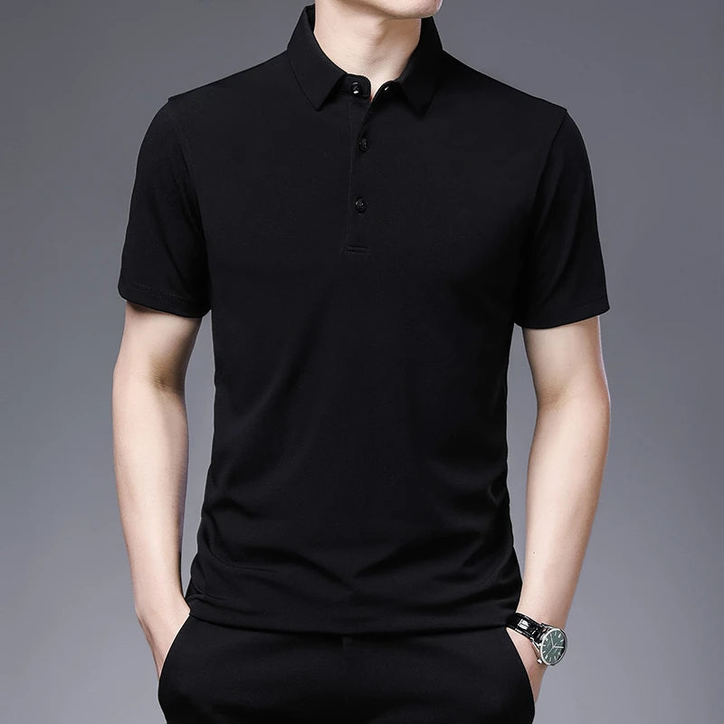 Person wearing a black polo shirt against a gray background