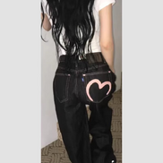 Rear view of a woman wearing dark-wash loose-fit jeans with contrast stitching and a pink heart outline on the right back pocket.