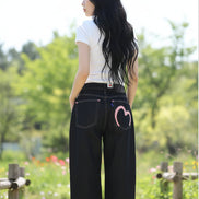Person wearing black jeans with a heart design on a white background