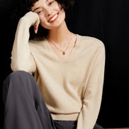 Woman wearing a beige cashmere sweater with 'Cashmere' branding.