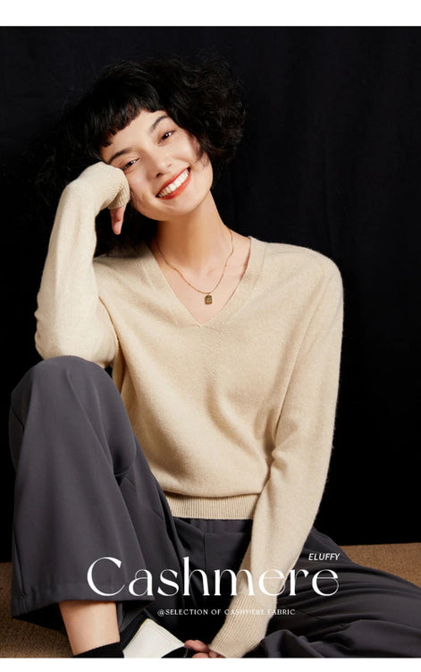 Woman wearing a beige cashmere sweater with 'Cashmere' branding.