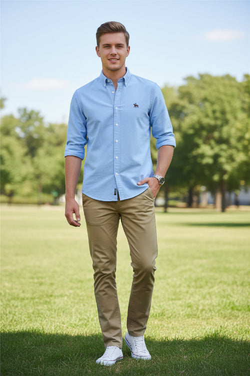 Folded light blue shirt with a small logo on a gray textured surface
