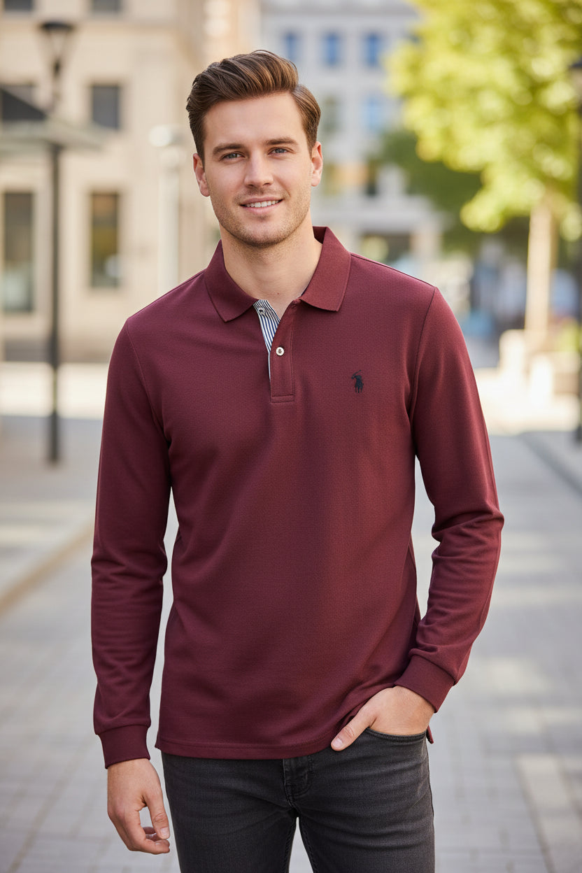 Maroon long-sleeve polo shirt on a hanger with other colored shirts in the background.