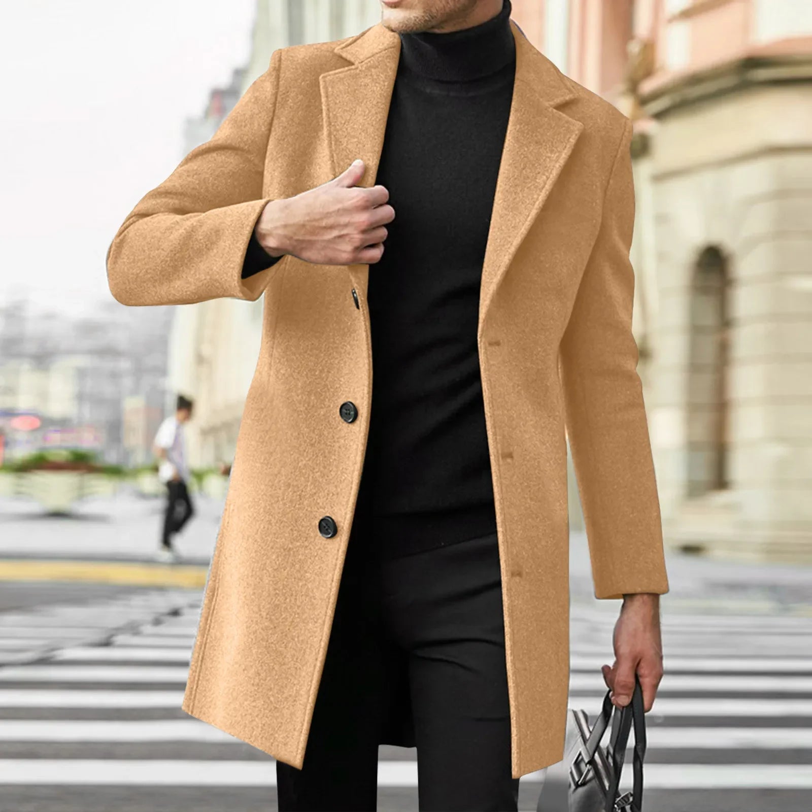 Person wearing a tan coat over a black outfit on a city street.