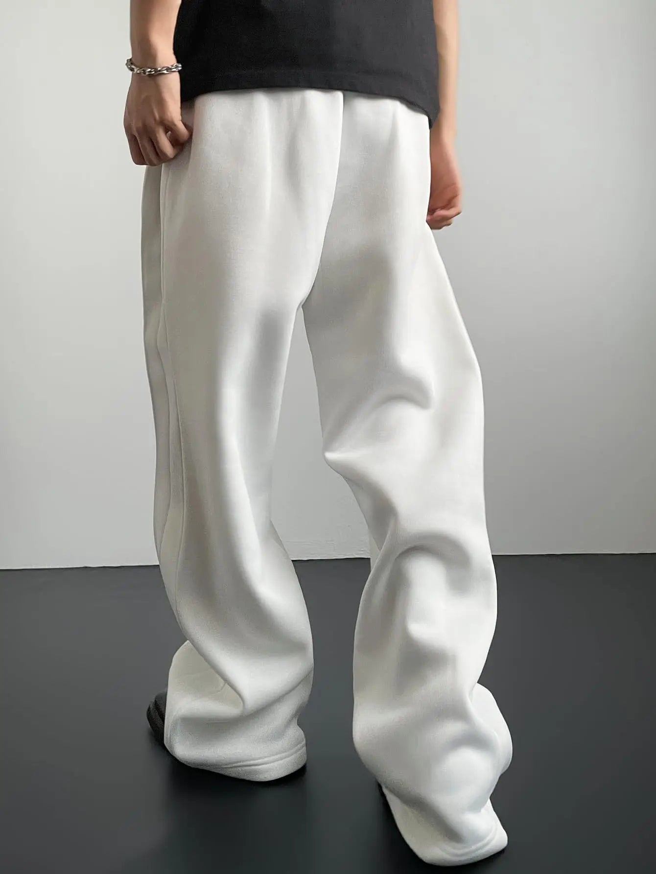 Person wearing white wide-leg pants against a plain background