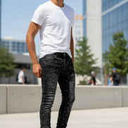 Black jeans with rhinestone embellishments on a white background