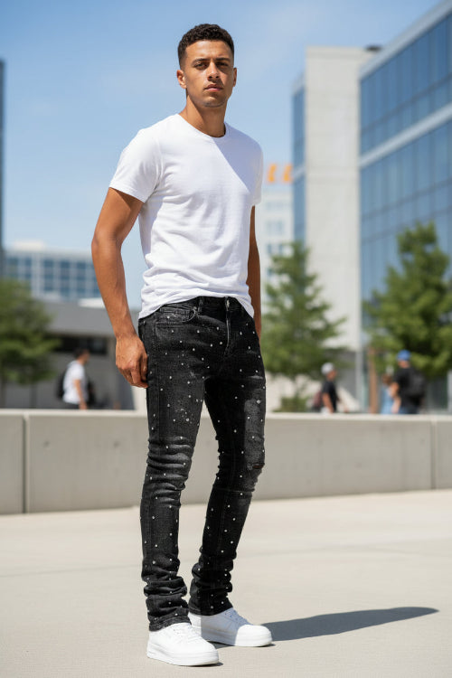 Black jeans with rhinestone embellishments on a white background