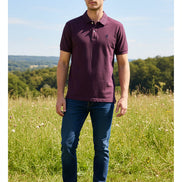 Purple polo shirt on a hanger with visible brand logo, against a blurred clothing rack background.
