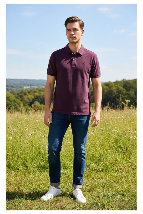 Purple polo shirt on a hanger with visible brand logo, against a blurred clothing rack background.