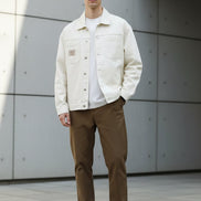 Beige denim jacket worn by a person on a white background