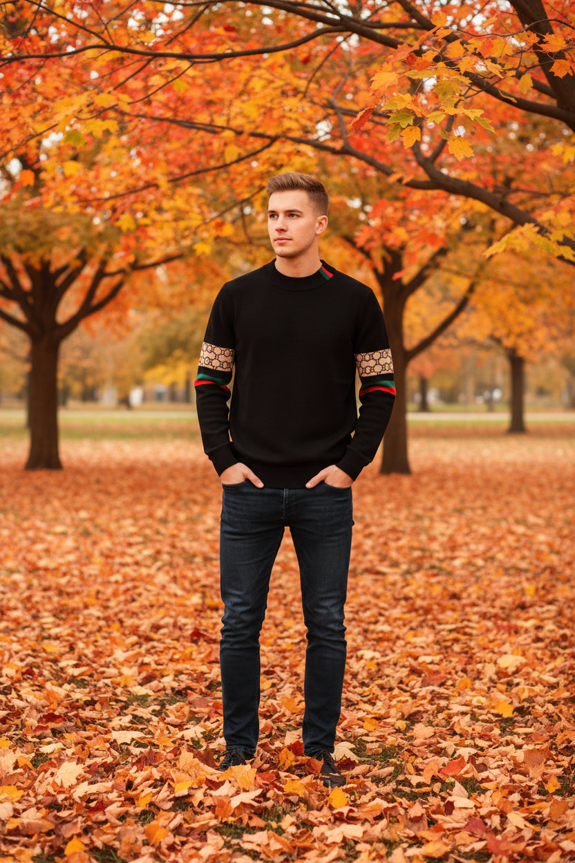 Black sweater with patterned arm bands on a white background