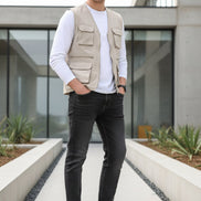 Brown leather shoes worn with rolled-up jeans on a wooden floor.
