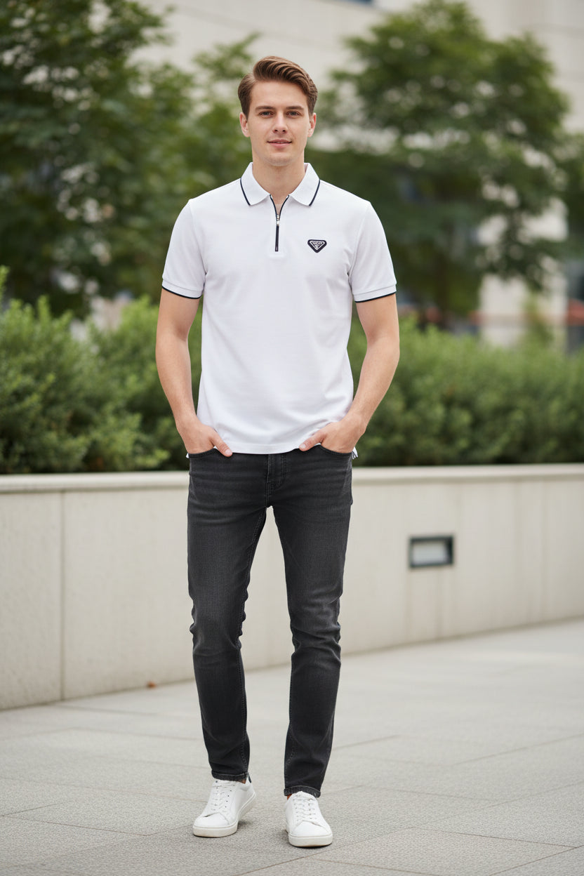 White short-sleeve polo shirt with a half-zip collar, black piping details on the collar, sleeve cuffs, and chest, featuring a small black chest logo and a red tag near the hem. The TACE&SHARK brand logo is visible in the top-left corner.