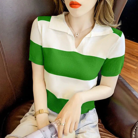 A woman wearing a short-sleeve knit polo shirt with bold green and white horizontal stripes, seated on a brown leather chair.