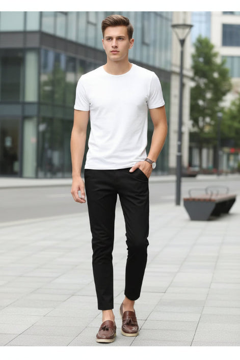 Person wearing black pants and brown shoes against a white background