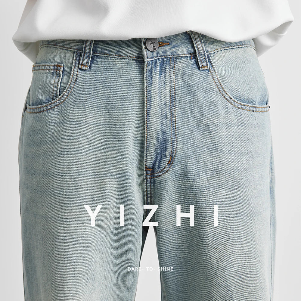 Light blue jeans with a white shirt on a light gray background, featuring the brand 'YIZHI'.