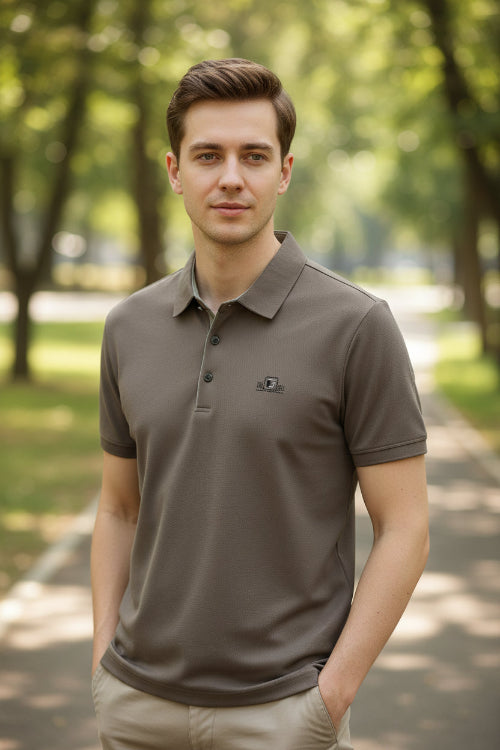 Brown polo shirt on a hanger with a hand touching the fabric