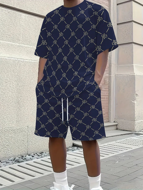 A person wearing a navy blue short-sleeve t-shirt and matching shorts set, both featuring a repeating beige monogram pattern. 